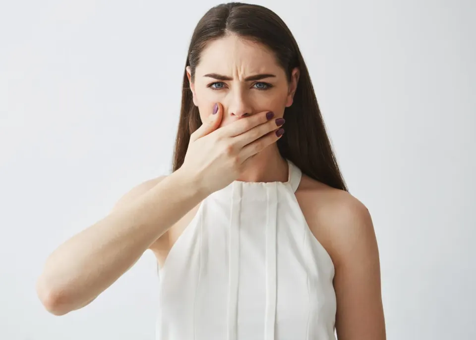 Dental hygienist explaining bad breath causes to patient at Enclave Dental